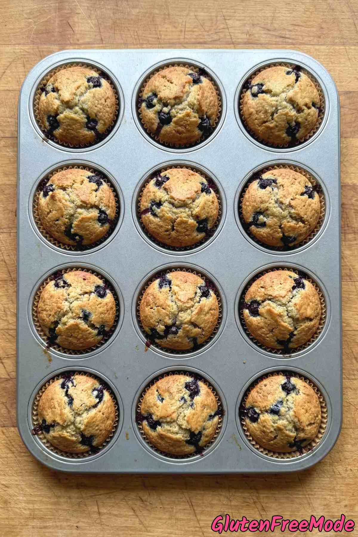 Golden gluten free blueberry muffins on a rack